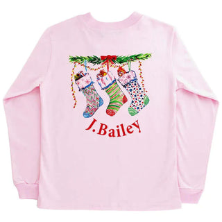 Pink girls long sleeve tee with festive Christmas stocking design and J. Bailey logo—perfect for holiday cheer and cozy days.