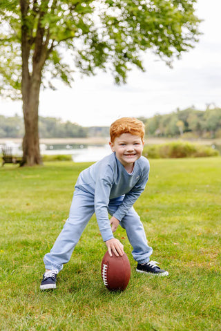 Boy playing football in Barrington Blue Gates Sweeney Sweatpants by The Beaufort Bonnet Company with embroidered stork logo.