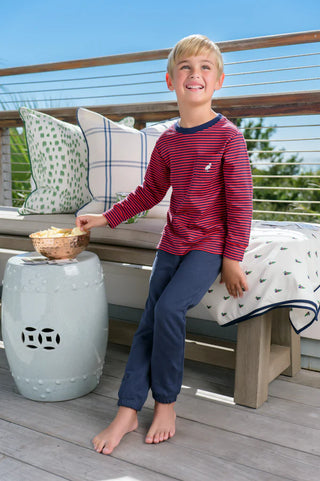 Boy in red striped shirt and Nantucket navy Gates Sweeney Sweatpants from The Beaufort Bonnet Company. relaxing on porch