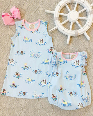 Sleeveless Polly Play Dress and Ruehling Ruffle Bubble by The Beaufort Bonnet Company in Doggy Paddle print, styled with nautical decor and a pink bow