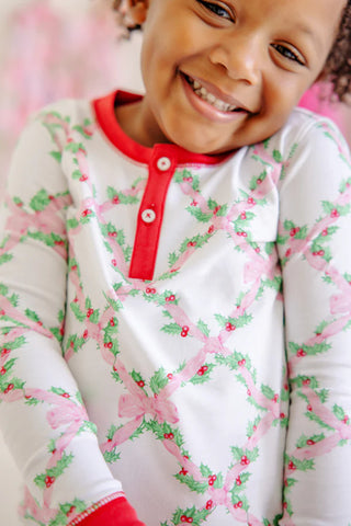 Close-up of girl smiling in TBBC Sara Jane's Sweet Dreams Set, showing festive holly and pink bows print with red trim