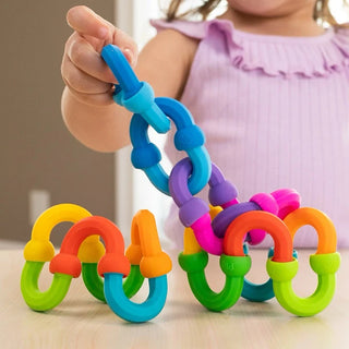 Close-up of a child’s hand building with brightly colored Plip Links, connecting them into swirling patterns and bendable designs.