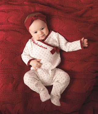 Ivory baby sleeper with red dots, ruffle trim, and bow, paired with matching headband—perfect for baby girl’s first Christmas.