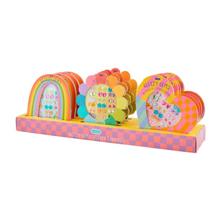 Colorful Mud Pie Glitzy Gems sticker earrings in rainbow, heart, and flower shapes—fun dress-up set for toddlers and little girls.