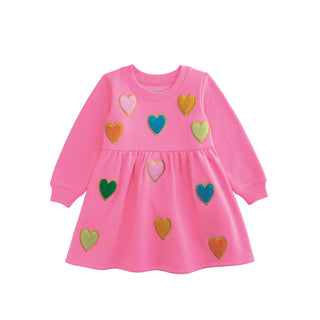 Pink sweatshirt dress with colorful boucle heart appliqués, long sleeves, and gathered skirt—cozy and cute for play or school.