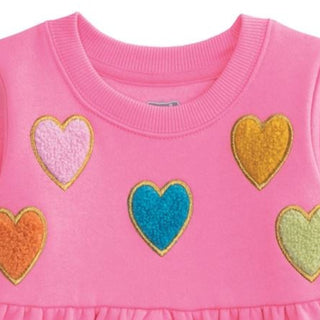 Pink sweatshirt dress with colorful boucle heart appliqués, long sleeves, and gathered skirt—cozy and cute for play or school.