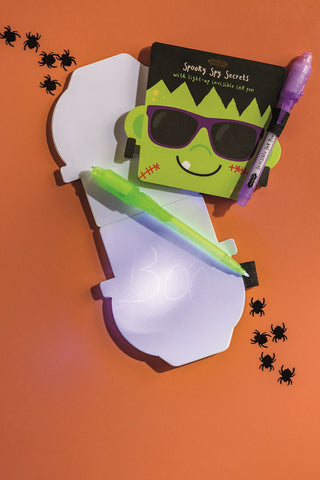 Halloween invisible ink pads with light-up pens—fun themed notebooks from Mud Pie in monster, pumpkin, and skeleton styles.