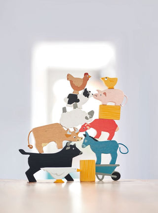 Stackable wooden farm animals set with barn bag—includes 10 animals, hay bale, and wheelbarrow for open-ended, screen-free play.
