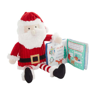 Mud Pie Santa plush wearing red and white, holding a removable soft Christmas book about decorating and holiday traditions.