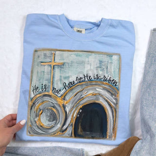 Premium garment-dyed cotton tee featuring a serene hand-painted design celebrating faith and the resurrection