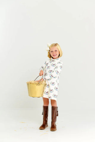 Girl wearing Highland Horses turtleneck dress with brown riding boots, holding brass bucket of hay, styled for an equestrian-themed outing