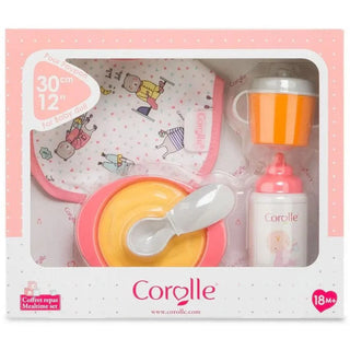 Boxed Corolle Mealtime Set showing bib, bowl, spoon, bottle, and cup sized for 12-inch baby dolls for nurturing pretend play.