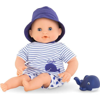 Bath Baby Marin doll sitting in nautical outfit of navy striped shirt and whale shorts and blue hat with whale toy beside him.