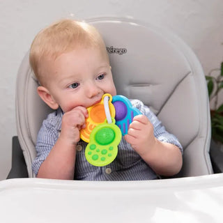 Baby exploring Fat Brain Toys Dimpl Clutch sensory key ring with soft silicone textures designed for teething and tactile play