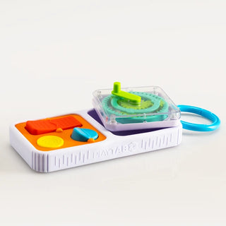 PlayTab Go board rests on table with colorful tiles and gears visible, highlighting toddler-friendly sensory activity features.