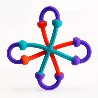 Completed starburst sculpture made from Plip Kit silicone pieces arranged in a symmetrical ball-and-socket design on white background.