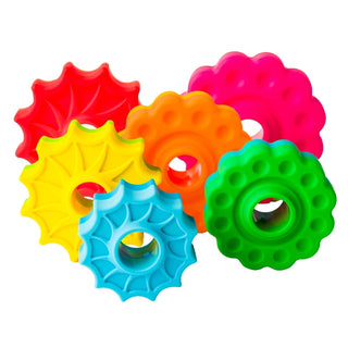 Close-up of six bright SpinAgain discs in red, yellow, orange, green, blue, and pink, each with unique texturesn a white background.