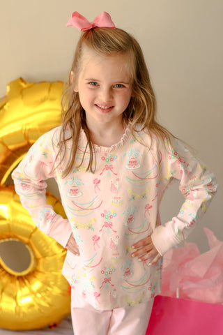 The Beaufort Bonnet Company Cassidy Ruffle Comfy Crewneck in Golden Birthday print, young girl posing in Pier Party Pink birthday sweatshirt.