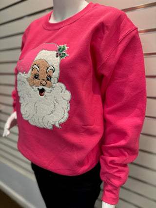 Hot pink sweatshirt on mannequin featuring vintage-style chenille Santa patch with textured white beard and sparkly pink hat details.