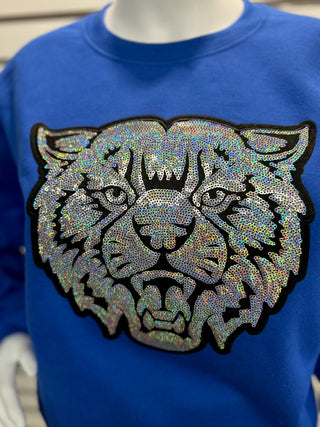Close-up of sequin UK Wildcat patch on royal blue heavy-weight sweatshirt highlighting sparkly details and embroidered outline.