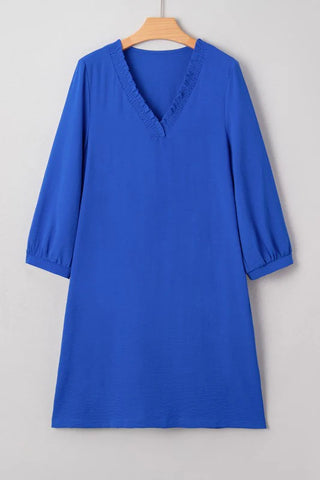 Blue ruffle V-neck dress from Little Daisy Closet with three-quarter sleeves and a relaxed, flowy fit hanging on a hanger.
