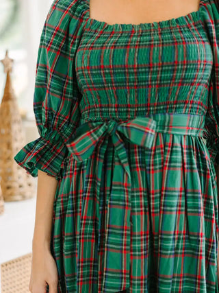 Close up view of classic green plaid holiday midi dress from LDC with bow tie waist, puff sleeves, and smocked bodice .