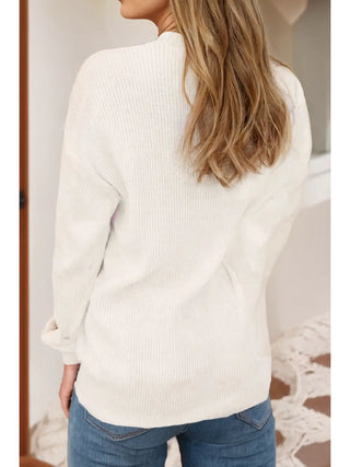 Back view of model in cream knit Merry and Bright sweater paired with jeans showing relaxed fit and cozy texture