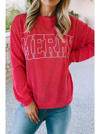 Front view of woman wearing red ribbed knit sweatshirt with large white MERRY lettering, worn casually with jeans.