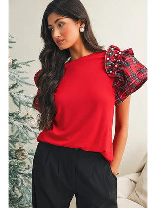 Front view of red holiday top featuring plaid ruffle sleeves with pearls, paired with black pants for a festive Christmas look.