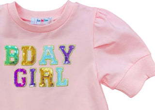 Close up of Lulu Bebe Puff Sleeve Pink Sequin BDay Girl Top with rainbow sequin lettering on soft cotton blend fabric.