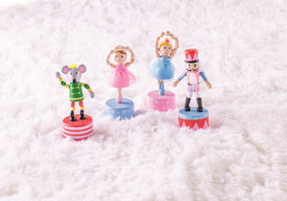 Nutcracker-themed wooden toys including ballerinas, Mouse King, and soldier that collapse and pop back up when pressed