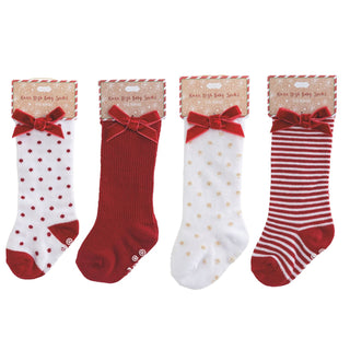 Mud Pie knee-high baby socks with holiday patterns and velvet bows—available in dots, stripes, and solids for 0–12 months.