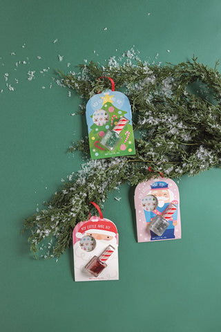 Mud Pie kids’ holiday nail kits in Santa, tree, and nutcracker designs with glitter polish and festive nail stickers.