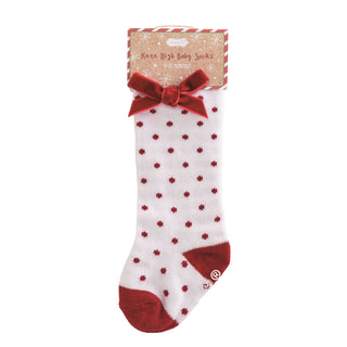 Mud Pie knee-high baby socks with holiday patterns and velvet bows—available in dots, stripes, and solids for 0–12 months.