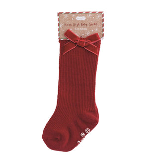 Mud Pie knee-high baby socks with holiday patterns and velvet bows—available in dots, stripes, and solids for 0–12 months.
