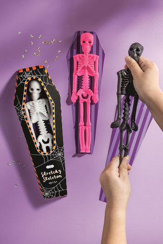 Mud Pie Stretchy Skeletons in coffin boxes—bendable Halloween sensory toys in white, pink, and black for spooky fun.
