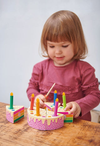 Wooden birthday cake toy with rainbow slices, candles, and slicer—perfect for pretend play and learning through celebration.