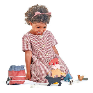 Stackable wooden farm animals set with barn bag—includes 10 animals, hay bale, and wheelbarrow for open-ended, screen-free play.