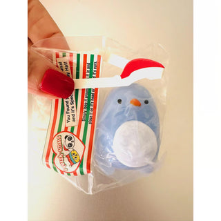 Hand holding a wrapped squishy penguin from Squish-Amal Advent Calendar - one of 24 surprise treats leading up to Christmas Day.