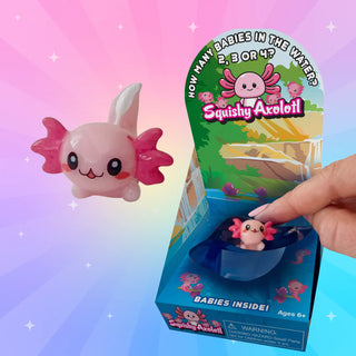 Close-up of a pink Squishy Axolotl baby figure being unboxed from the mystery packaging for a fun surprise reveal.