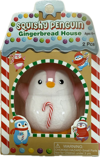 Pink penguin squishy toy with red candy cane, packaged in festive gingerbread house box, collectible Christmas toy.