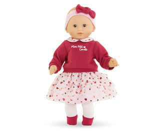 Close-up of Corolle Bebe Calin Margaux Heart Petals doll wearing red top, heart collar and skirt, and pink bow headband.
