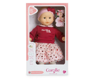 Corolle Bebe Calin Margaux Heart Petals doll wearing red top, heart collar, and pink bow headband packaged in retail box.